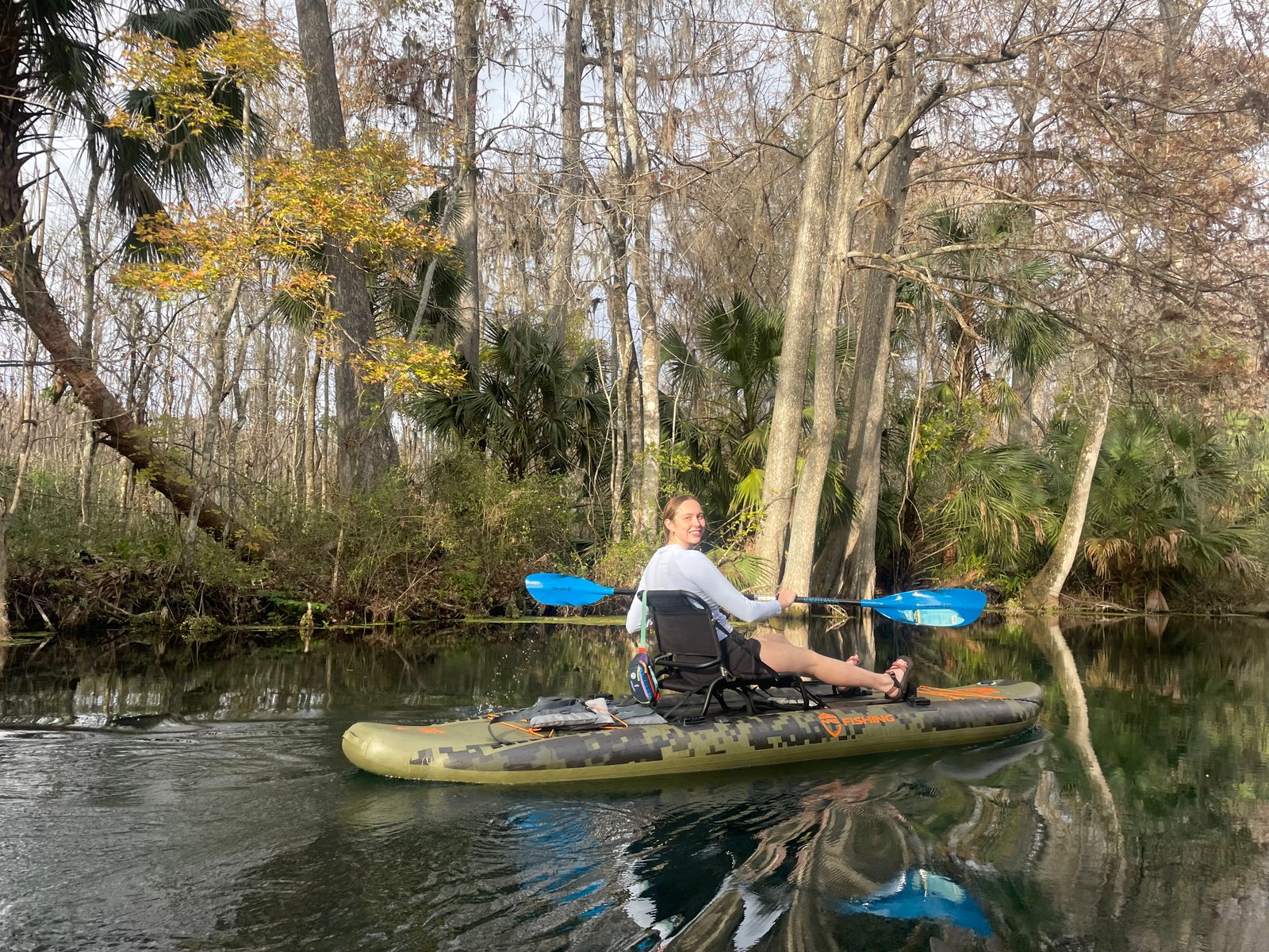 Kayaker paddling through calm water surrounded by cypress trees at Silver Springs State Park
