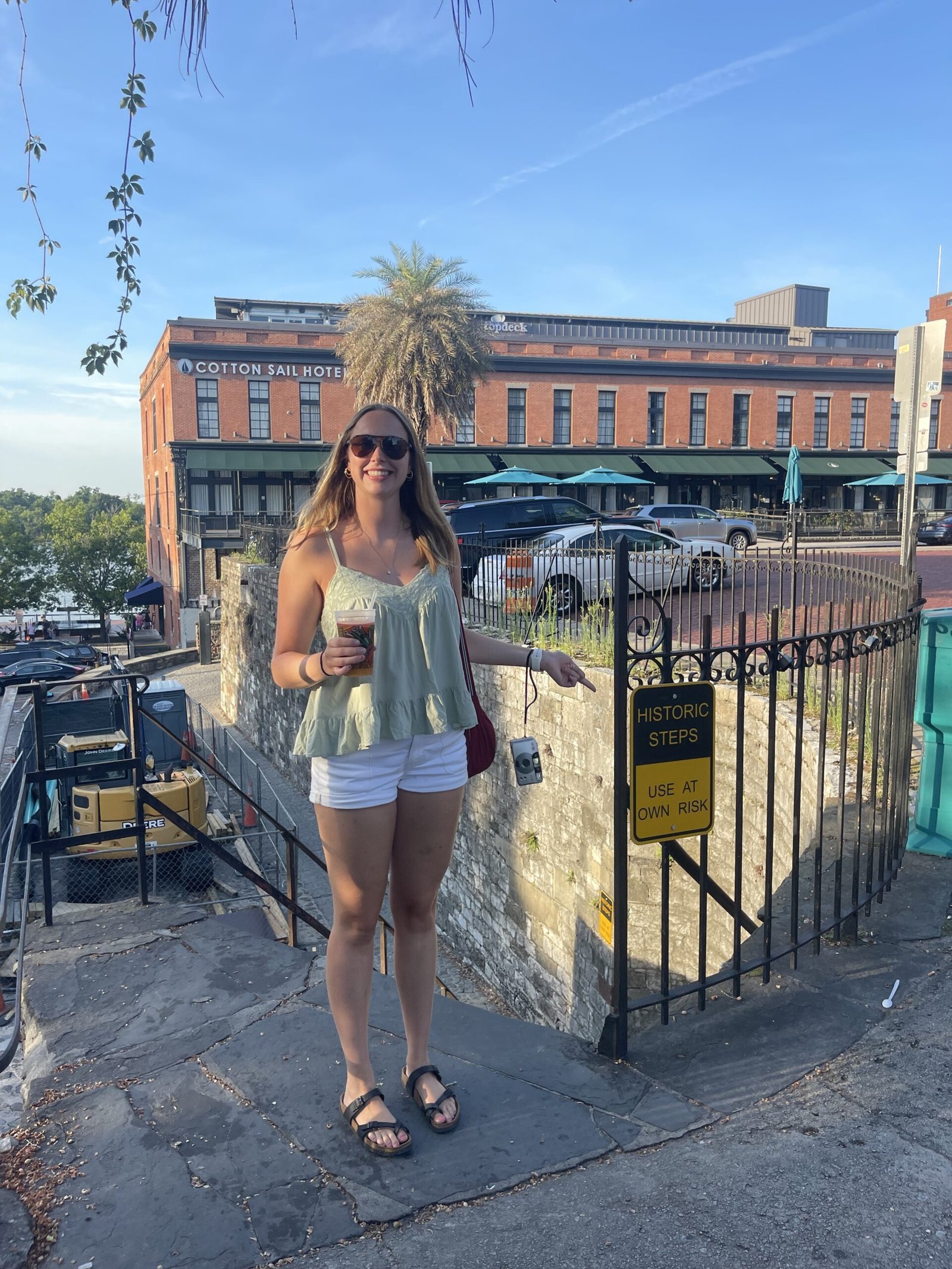 Woman posing near historic steps sign by the Cotton Sail Hotel in Savannah